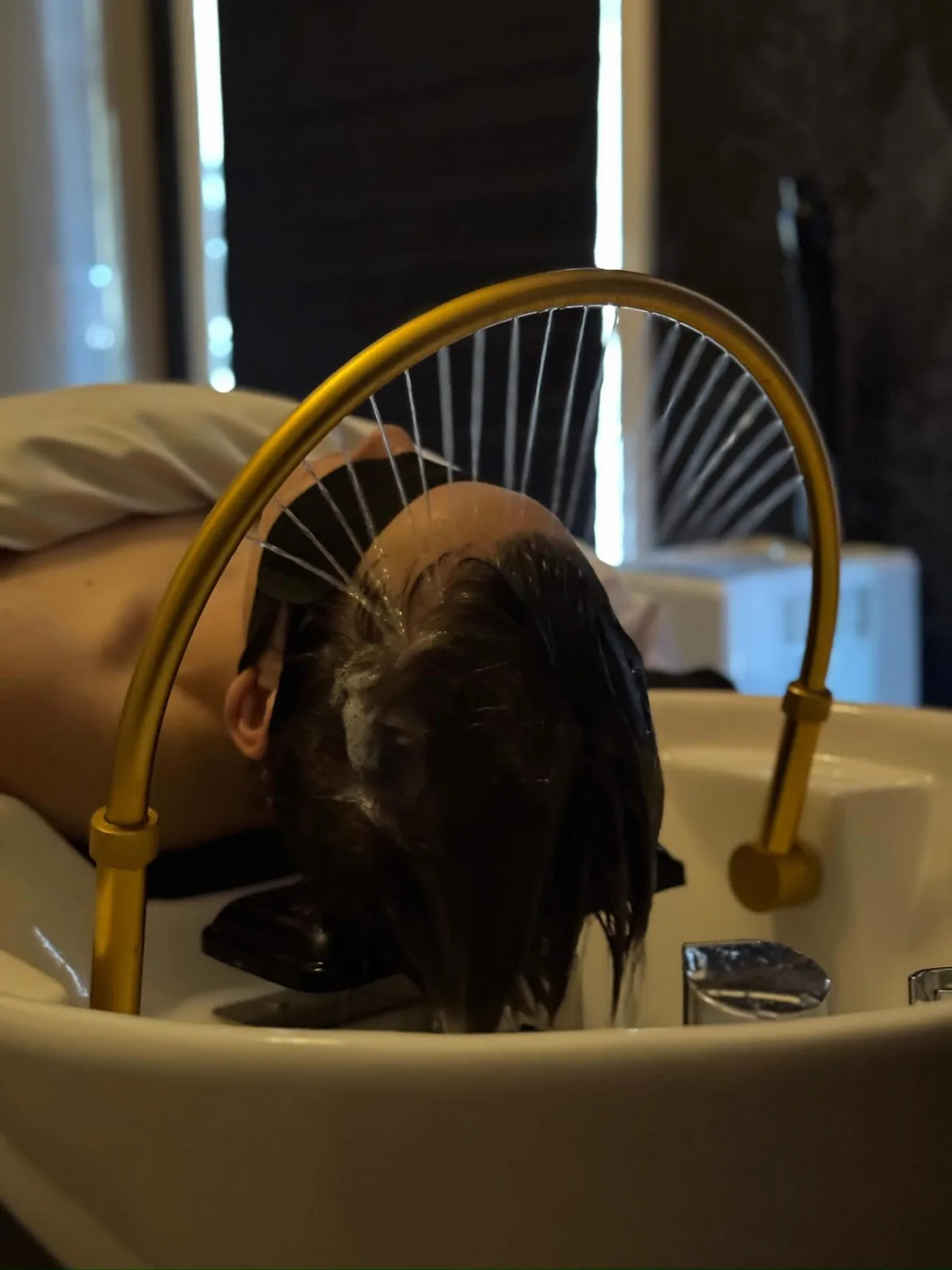 Guest receiving halo-inspired water therapy over the Sanctuary treatment basin